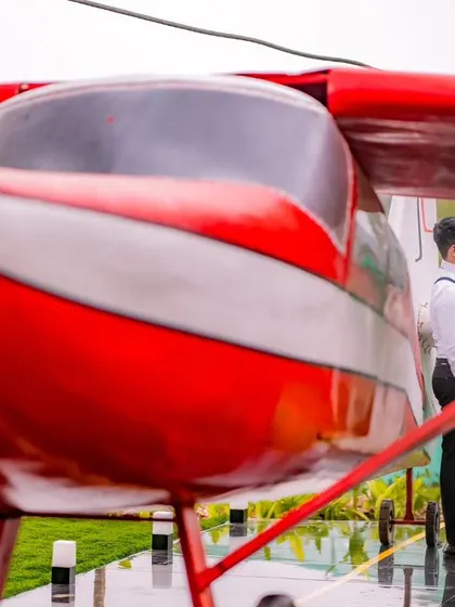 Adventure awaits. This unique maternity shoot features a vintage red airplane prop, symbolizing the new journey the couple is about to embark on together. It's a fun and creative option for your session.