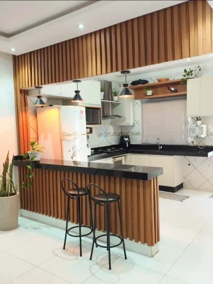 This kitchen uses vertical wood slats to create a stunning feature wall that extends from the breakfast bar. It's a great way to add texture and warmth to the space.