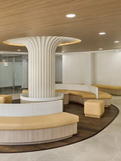 The waiting area at SPS Hospital Clinic features a sculptural central column and curved, organic seating. This design uses neuro-aesthetic principles to create a calming, fluid space that reduces patient anxiety and enhances comfort.