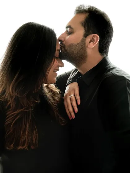 Close up on a tender forehead kiss, showcasing the deep affection and partnership during the pregnancy journey.