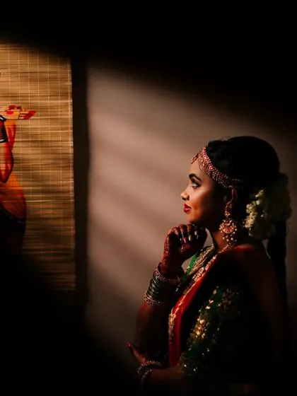 An artistic and moody bridal portrait, where the bride gazes at a painting, with dramatic shadows creating a contemplative atmosphere.