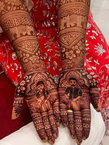 The rich, dark stain of a custom portrait mehendi, with the faces of the couple clearly visible.