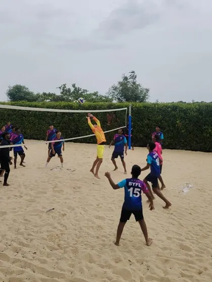A player leaps to spike the ball during a beach volleyball game. This cross-training activity is a fun way to build athleticism.
