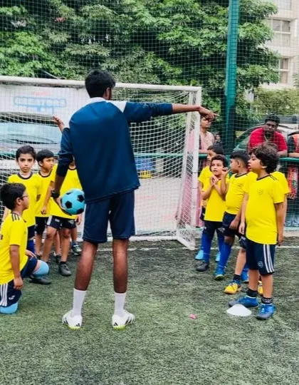 A coach instructs his team on positioning before a drill. We teach the tactical side of the game from an early age.