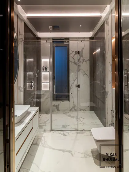 A frontal view of the same bathroom, showcasing the clean lines of the floating vanity and the seamless glass shower door. The design feels spacious, modern, and impeccably detailed.