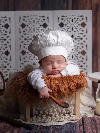 Baked with love. A newborn baker sleeps peacefully in a basket, surrounded by all the ingredients for a sweet life.