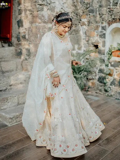 A graceful full-length portrait of the bride. Her gentle movement and the elegant drape of her lehenga create a sense of timeless beauty.