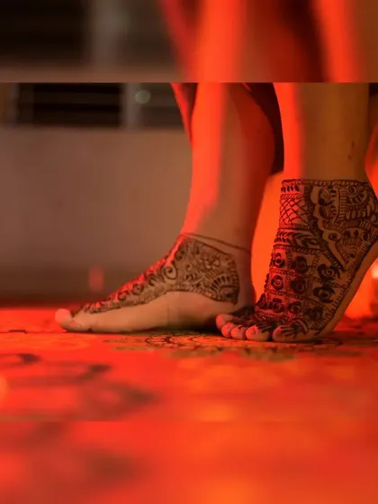 A close-up shot focusing on the intricate mehendi designs on the bride's feet. I ensure that no detail is overlooked, capturing the full extent of the bridal henna.