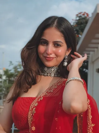 A close-up of the client, her smile as bright as her red lehenga.