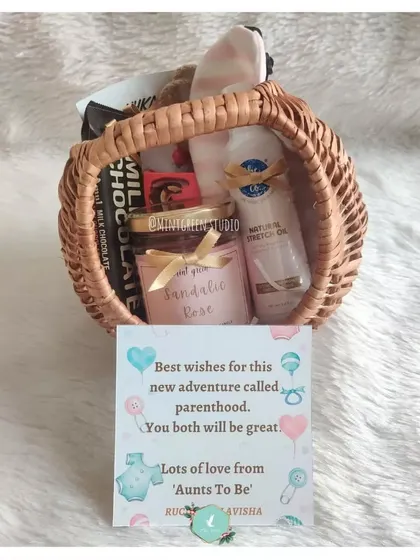 Celebrating the new adventure of parenthood. This hamper in a cane basket is filled with self-care items like stretch mark oil and a scented candle for the mom-to-be.