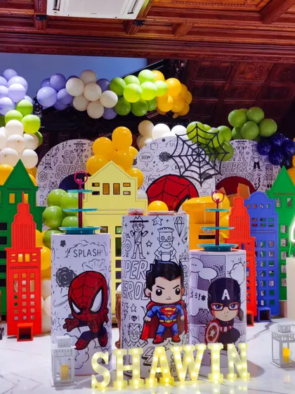 The superhero setup again, this time focusing on the custom-printed character plinths that serve as dessert stands. It's a great example of how I integrate functional elements into the theme.