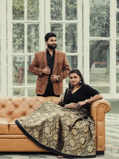 A classic portrait in a beautifully lit room with large windows, capturing the couple's regal and composed presence.