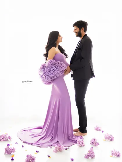 A unique and fashionable maternity portrait featuring a lavender gown with a large floral detail. This photo showcases a modern and artistic approach to studio maternity photography.