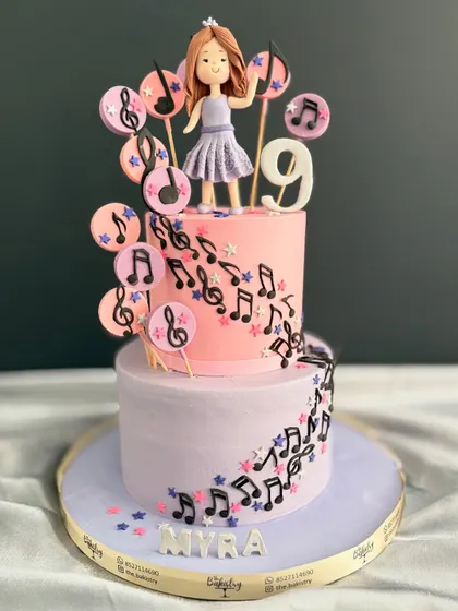 A little bit of magic in every slice! This two-tiered cake for Myra's 9th birthday features a cascade of musical notes and a custom topper of a girl singing her heart out.