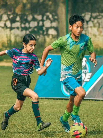 A girl and a boy compete for the ball, highlighting the inclusive nature of my tournaments.