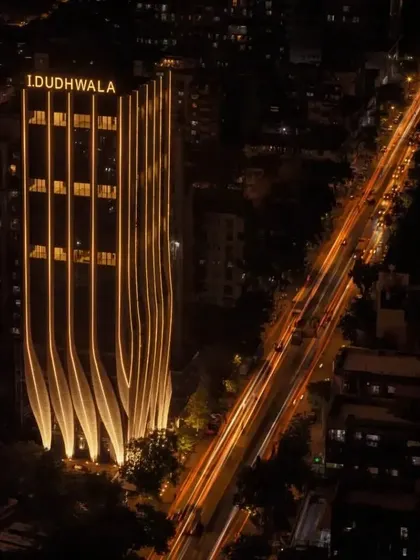 The full height of the tower at night, with the calligraphic facade creating a powerful visual statement against the dark sky.