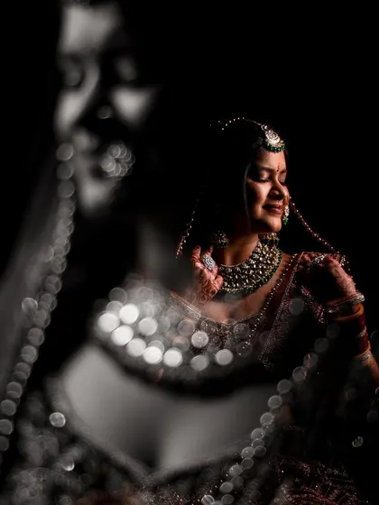A creative portrait using a prism or reflection to create a dreamy, layered effect. This artistic black and white shot captures the bride's happiness in a unique and memorable way.