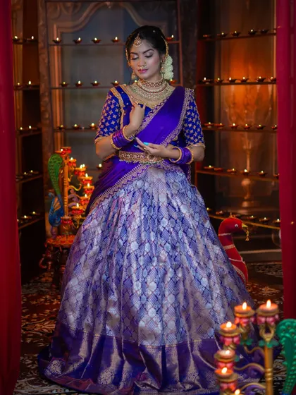 The intricate details of the embroidered blouse and the layered necklaces are highlighted in this shot.