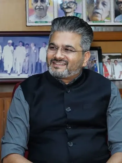 A candid moment in the chairman's office, surrounded by photos of past achievements and great leaders like Swami Vivekananda.
