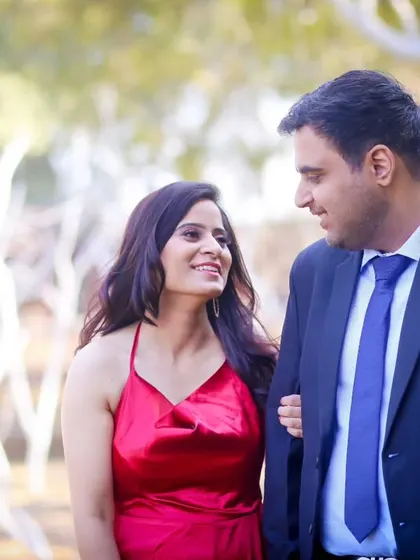 A colourful and romantic walking portrait from a pre-wedding shoot. The couple's connection is evident in their shared glance and happy smiles.