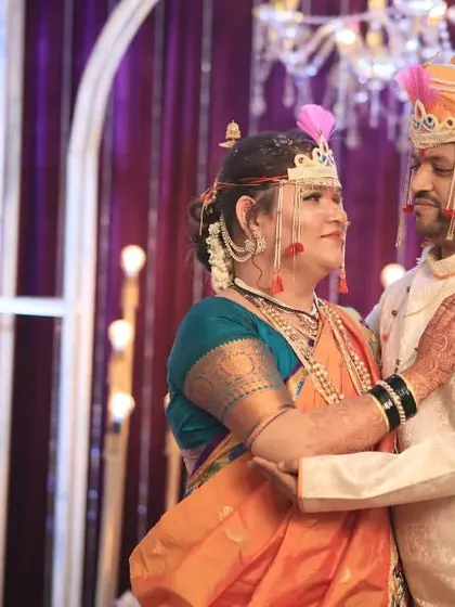 A tender moment between the newly married couple, framed by the elegant decor of their Maharashtrian wedding reception.