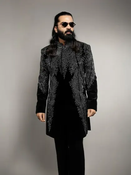 This black velvet indowestern is fully embellished with cascading silver beadwork. It's a glamorous and modern option for a cocktail party or New Year's Eve event.