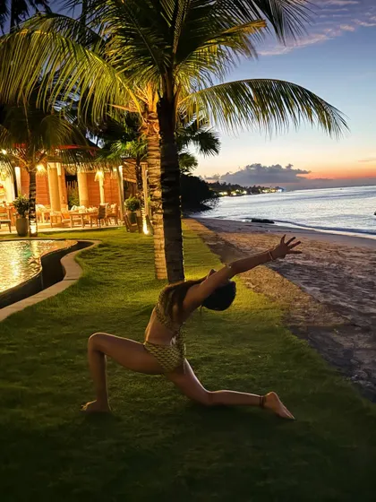 As dusk settles over the Bali coast, we find moments of peace and reflection. This gentle low lunge, performed on the soft grass by the sea, is a perfect way to unwind and absorb the energy of the ocean.