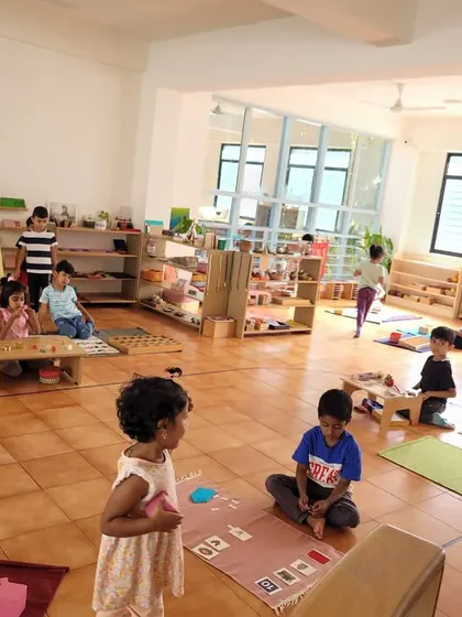 A wide shot of our classroom shows the "flow" of a Montessori work period. Children move freely, choose their work, and engage deeply, while teachers observe and provide individual lessons.