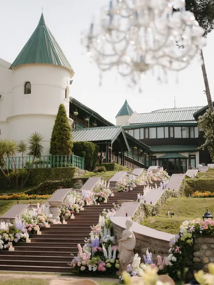 The entrance to the ceremony was a grand staircase lined with cascading pastel floral arrangements and candles. This created a breathtaking path for the bride, building anticipation for the moment she would walk down the aisle.