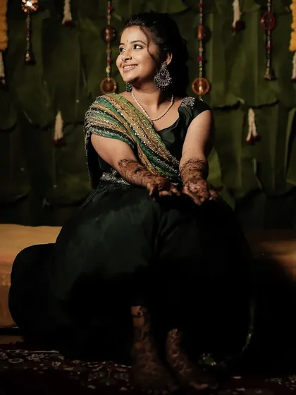 Varshini seated for her Mehendi ceremony, looking relaxed and beautiful.