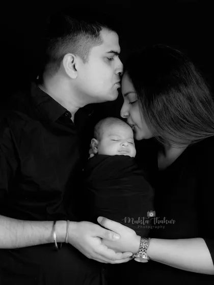A black and white portrait that captures the love and protection of new parents.