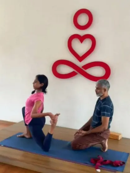 During a workshop, I guide a student in a modified kneeling backbend. My hands on her back provide stability and encourage a deeper opening through the chest and thoracic spine. This is a great example of how I tailor my approach to each individual's body.