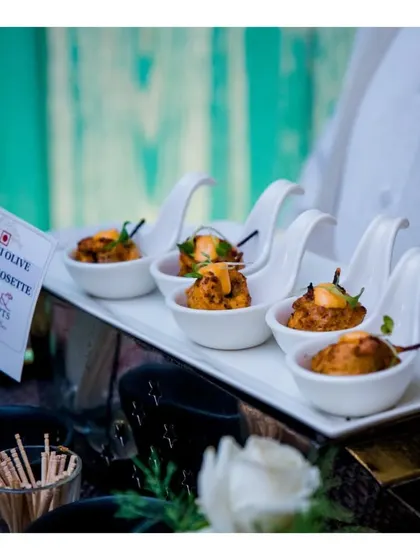Peri Peri Olive Chicken Rosettes served in individual porcelain spoons, a flavourful and beautifully presented canapé.