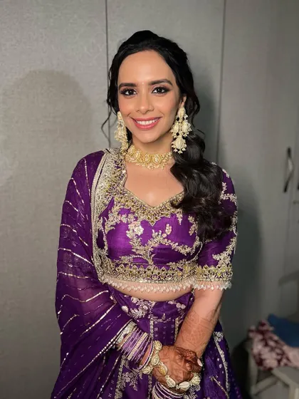 Dr. Archita looking radiant and happy. The gold jewelry and purple outfit are a stunning combination.