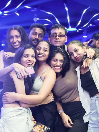 A tight-knit group of friends hugging and smiling. My music brings people closer together on the dance floor.