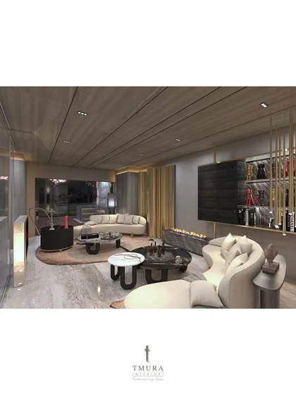 This penthouse lounge is designed for ultimate comfort and style. A long, curved sofa faces a modern, linear fireplace, while a custom brass shelving unit serves as a stylish and functional bar area.