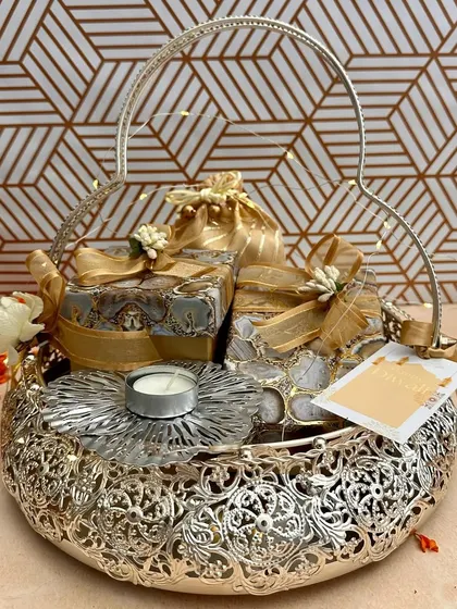 This ornate silver-finish basket is filled with beautifully wrapped gift boxes and a delicate floral T-light holder. It’s a wonderful example of how I balance traditional craftsmanship with modern gifting aesthetics.