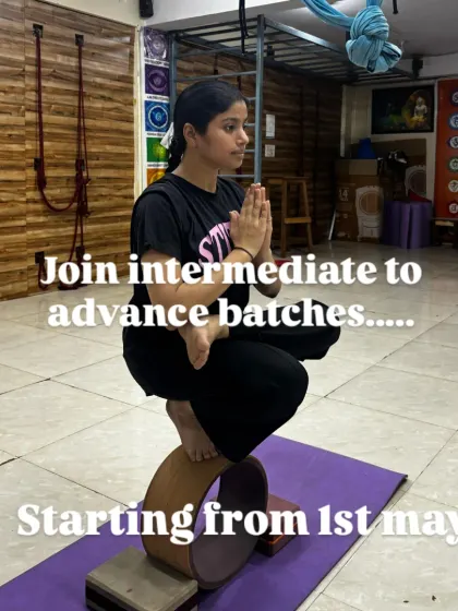 A student demonstrates incredible focus while balancing in Padmasana (Lotus Pose) on a yoga wheel, announcing our intermediate to advanced batches.