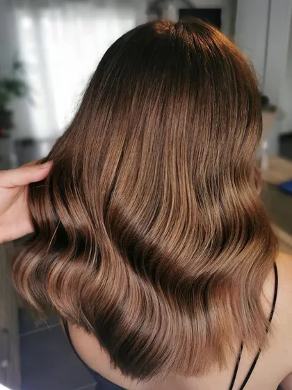A gorgeous caramel brunette look. The soft waves perfectly showcase the rich, warm tones created with a custom Wella formula.