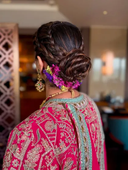 A close-up of this beautiful braided bun. Adorned with fresh, colorful flowers, this hairstyle is perfect for a daytime event like an Anand Karaj or Mehendi.