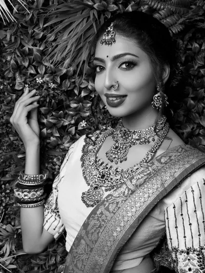 A timeless black and white portrait of a model. The lack of color emphasizes her expression, the texture of her saree, and the sparkle of her jewelry, creating a classic and artistic shot.