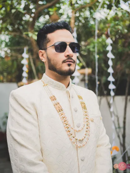 The groom's style is just as important. This shot captures Aditya's cool demeanor and his layered pearl necklace.