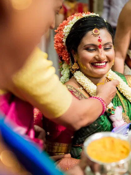 A close-up of the radiant mother-to-be as she receives blessings during her baby shower ceremony. Her smile lights up the frame.