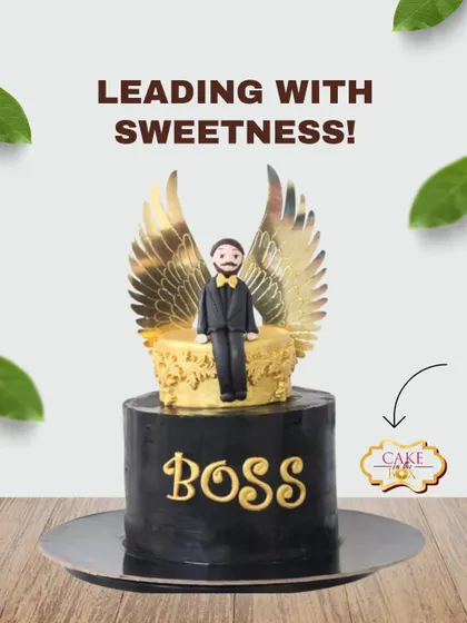 A cake fit for a boss, leading with sweetness. This black and gold cake features a custom fondant figure of the boss with golden wings, sitting on a throne.