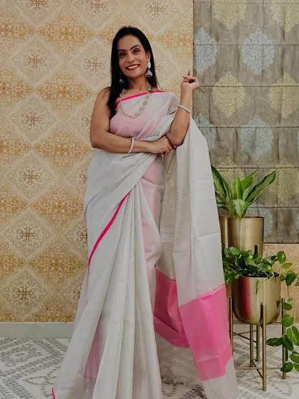 This white and pink tissue saree is simple, elegant, and very graceful. It's a versatile piece that can be worn for many different occasions.