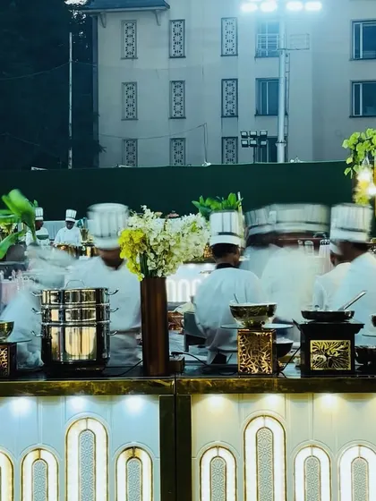 My team of chefs ready for service at a beautifully lit buffet station. The motion blur captures the energy and buzz of a live catering event just before guests arrive.
