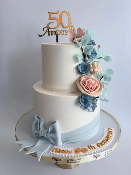 Another angle of the elegant 50th-anniversary cake, displayed on a beautiful gold stand.