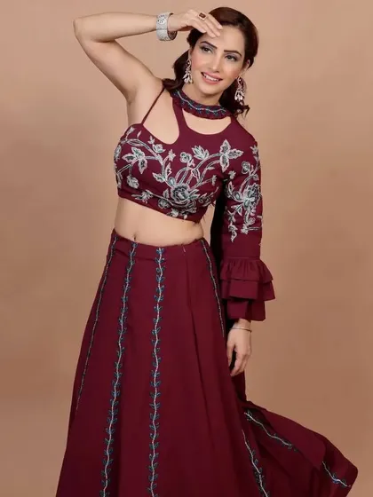 I love creating fusion wear, and this maroon Indo-Western lehenga set is a personal favorite. The crop top features intricate floral embroidery, paired with a flowing skirt, making it a stunning choice for a wedding guest or festive party.