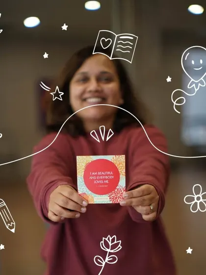 A participant proudly displays an affirmation card. Our workshops provide tools and practices to help you nurture more positive self talk in your daily life.