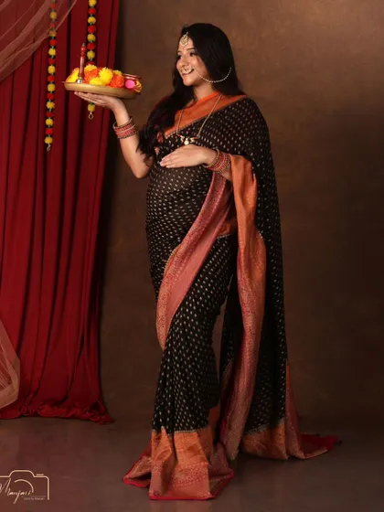 Holding a thali of flowers, this mama-to-be looks radiant and graceful in her traditional attire.